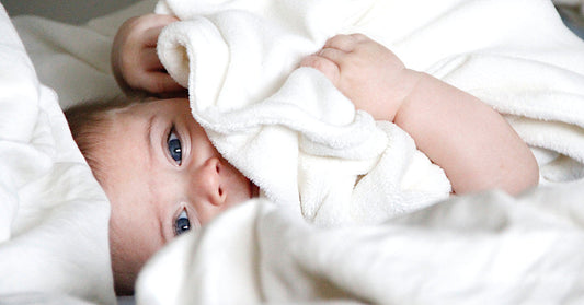 Bébé mixte enveloppé dans une couverture blanche, image principale de l’article sur les prénoms mixtes 2026