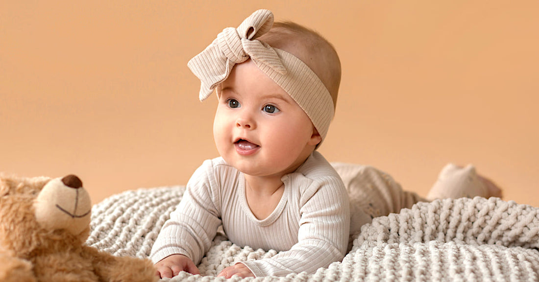 Bébé éveillé allongé sur couverture beige, ambiance douce et poétique