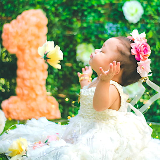 Bébé habillé d'une robe blanche élégante avec couronne de fleurs, sélection tenues de cérémonie bébé fille  de seconde main Chou de Chic